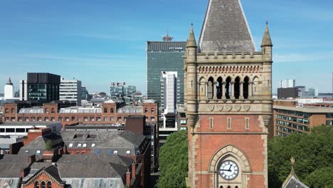 aerial drone flight in close proximity to manchester crown court clocktower with a view of city tower in piccadilly gardens