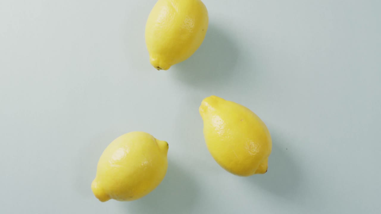 Video of fresh lemons lying on grey background