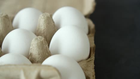 primer plano de huevos blancos en una caja de cartón