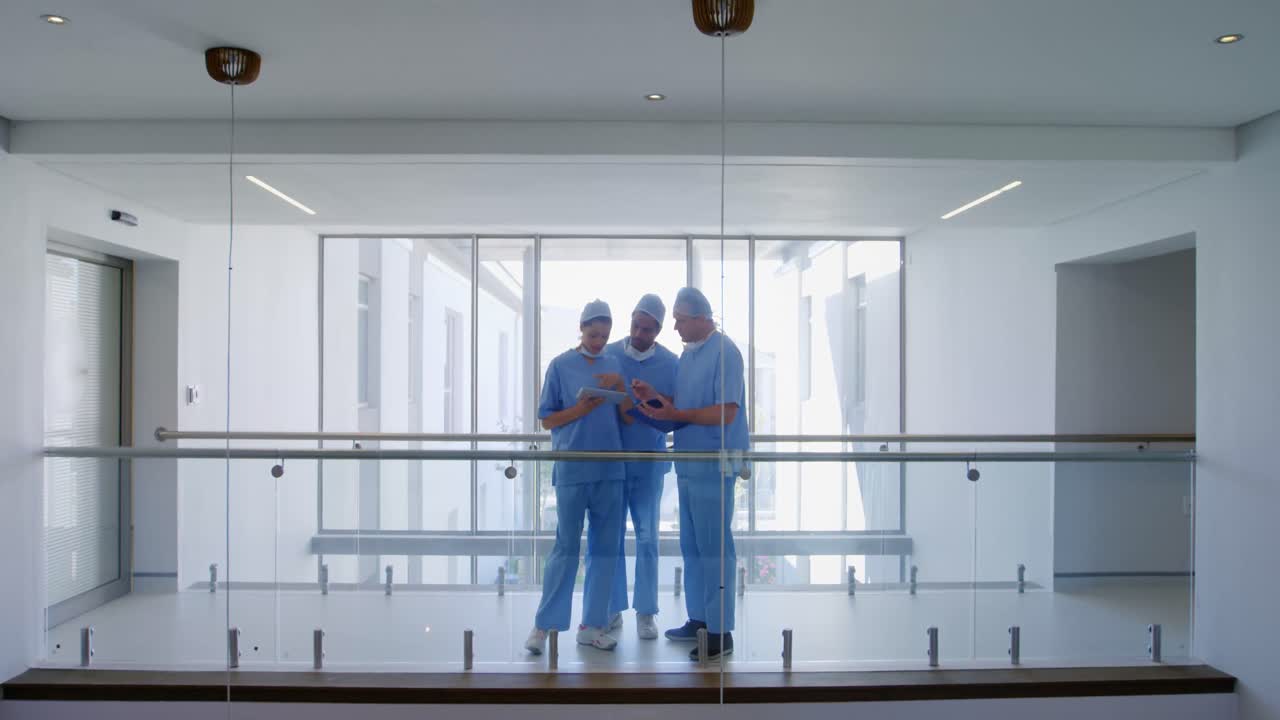 equipo de cirujanos discutiendo sobre una tableta digital