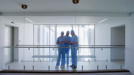 Team of surgeons discussing over digital tablet