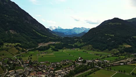 panoramic drone shot of a small village surrounded by the swiss alps, brienzer rothorn mountain in emmental alps, switzerland, europe