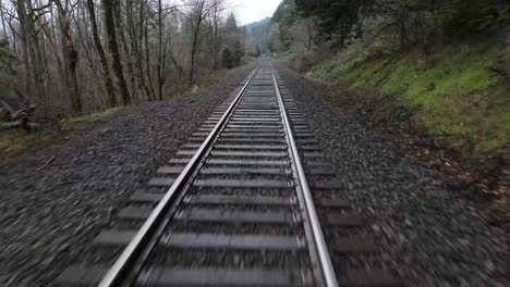 Luftdrohne-Im-Niedrigen-Winkel-Entlang-Einer-Bahnstrecke-Aus-Der-Perspektive-Des-Zuges