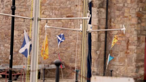 various flags waving on a boat mast