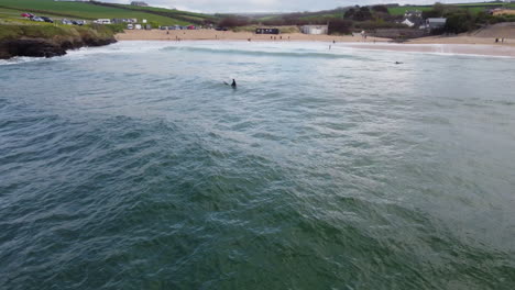 surfers enjoying the rough seas of the cornwall coast at harlyn bay