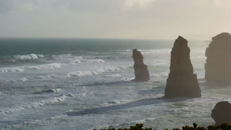 ocean waves hitting rock formations at sunset