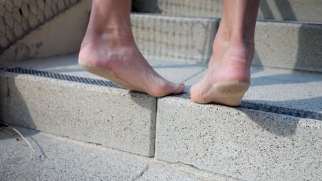 barefooted person stretching leg calves and soles