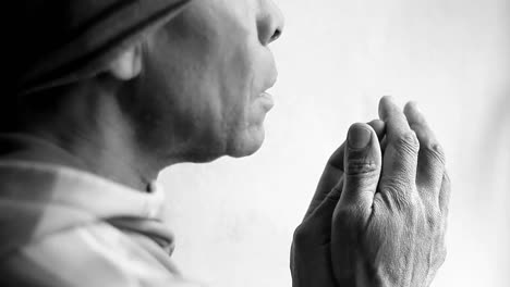 black and white close-up of a person in prayer