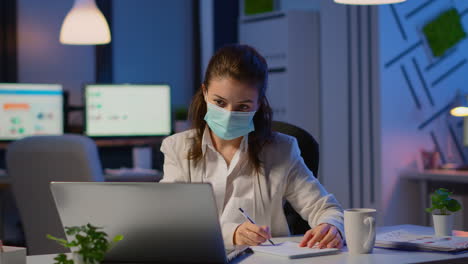 empleado con máscara de protección facial trabajando tarde en la noche en una nueva oficina normal
