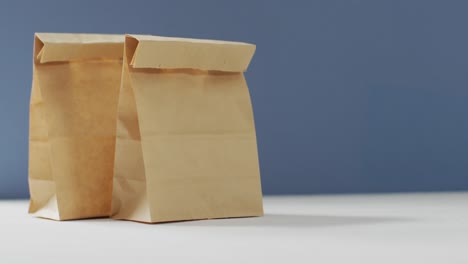 animation of paper lunch bags on blue background