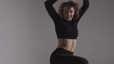 Three-Quarter-Length-Studio-Shot-Of-Young-Woman-Doing-Dance-Practise-Against-Grey-Background-2