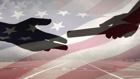 Composite-video-of-american-flag-over-silhouette-of-hand-passing-a-baton-against-sports-track