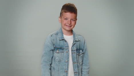 toddler boy smiling friendly at camera and waving hands gesturing hello or goodbye, welcoming