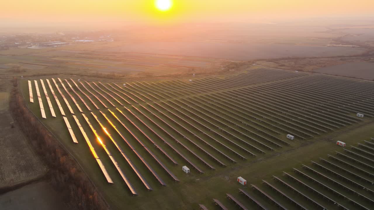 Luftfoto af stort bæredygtigt elkraftværk med mange rækker af solcellepaneler til produktion af ren elektrisk energi ved solnedgang. Vedvarende elektricitet med nul-emissionskoncept
