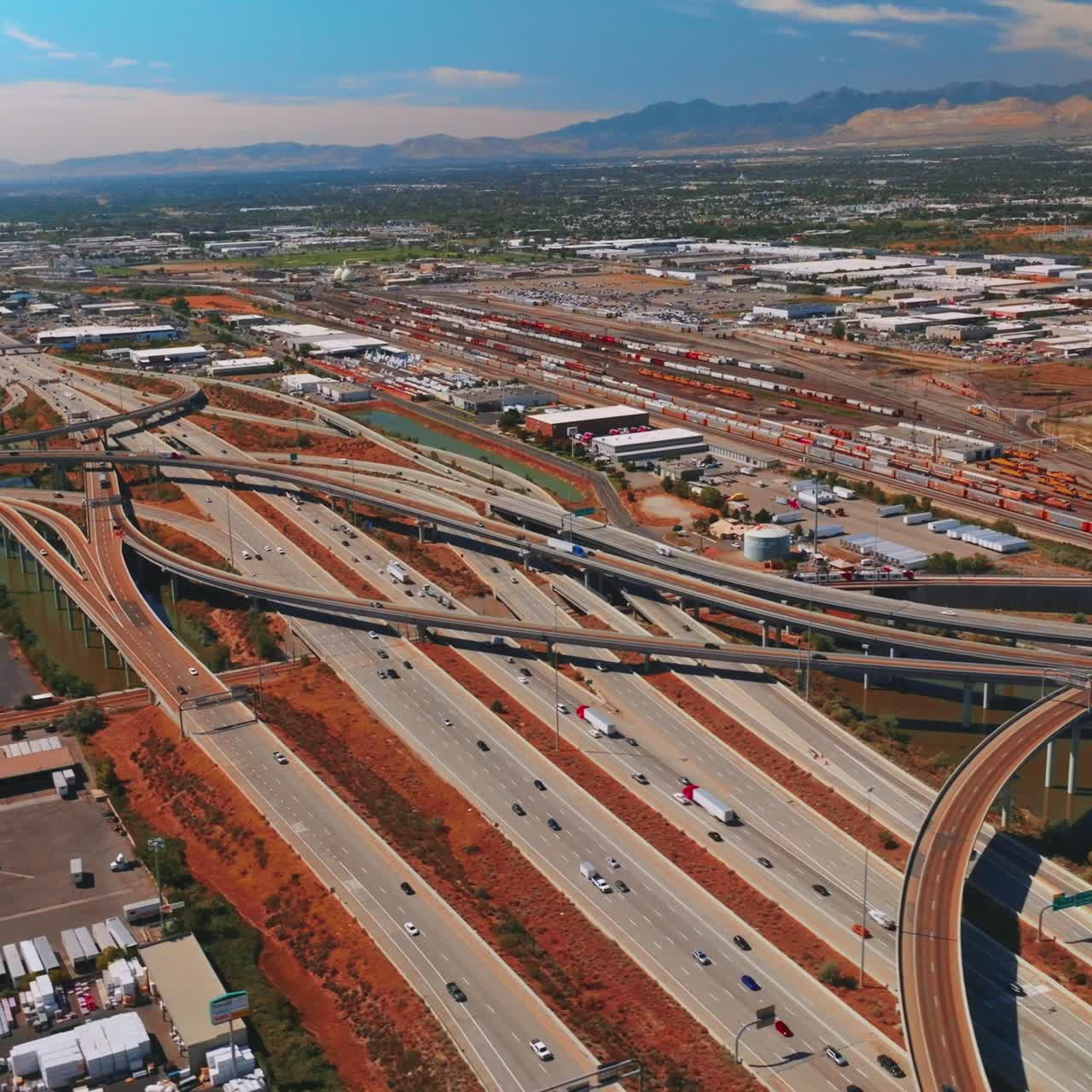 Multiple cars on the twining roads of Salt Lake City, Utah, USA. Sunny urban landscape with mountains at backdrop