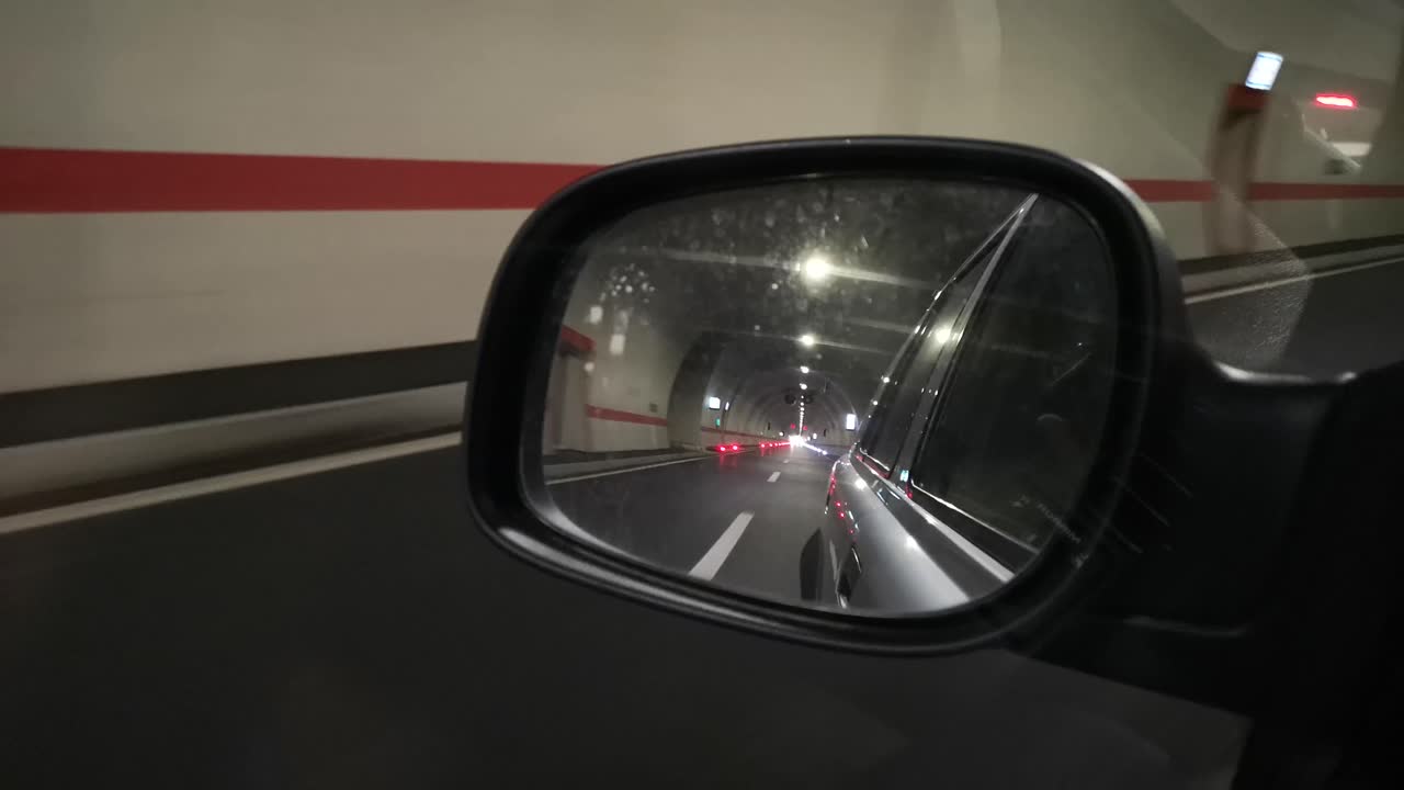 pasando por el túnel de la autopista y mirando en el espejo retrovisor