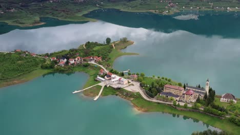 fly over drone shot of the saint franciscan monastery at rama lake