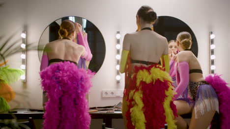 three showgirls applying makeup in the backstage 4