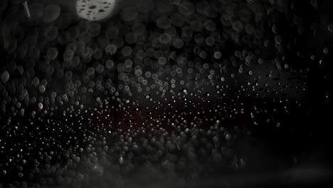 raindrops at night creative footage black background. rainy weather. take three.