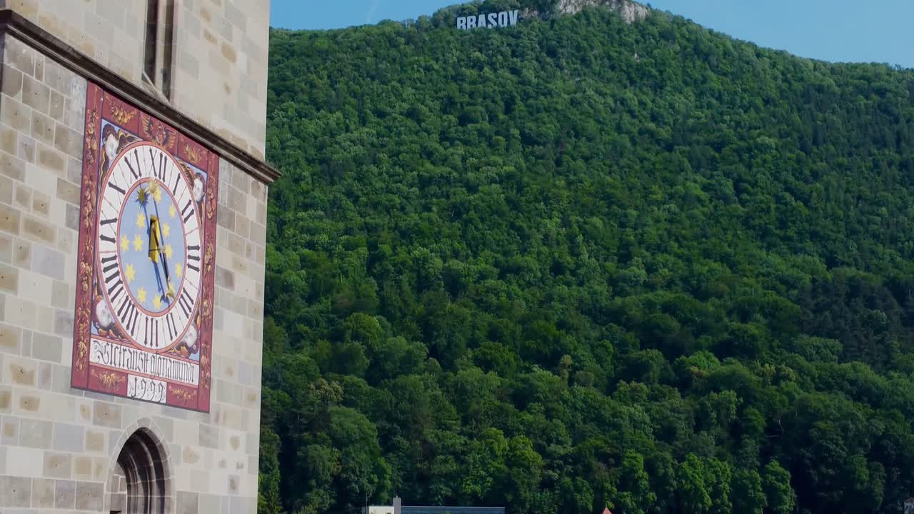 Cinematic reveal of Brasov Sign on Mount Tampa looking from The Black Church in Brasov Old Town - Romania