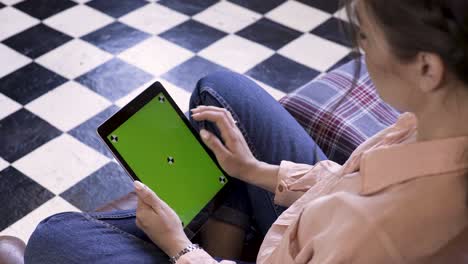 woman using a tablet with a green screen