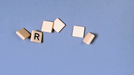 Plastic-letters-bouncing-and-spelling-out-Friday-on-blue-surface