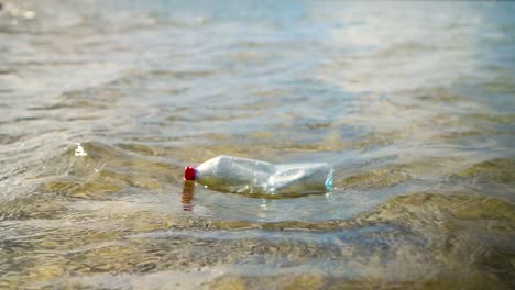 Cámara-Lenta-De-Botella-De-Plástico-Flotando-En-Aguas-Claras-Y-Poco-Profundas-Del-Océano