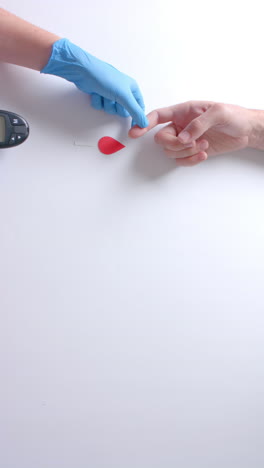 vertical video of hands of caucasian doctor and patient checking blood sugar level, slow motion