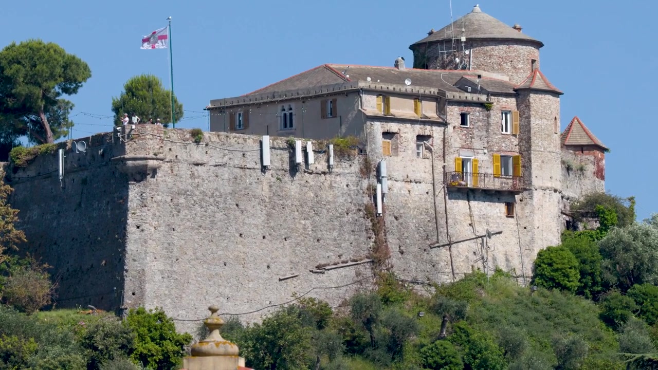 Una lenta panoramica rivela un castello storico in pietra sotto un cielo azzurro e limpido