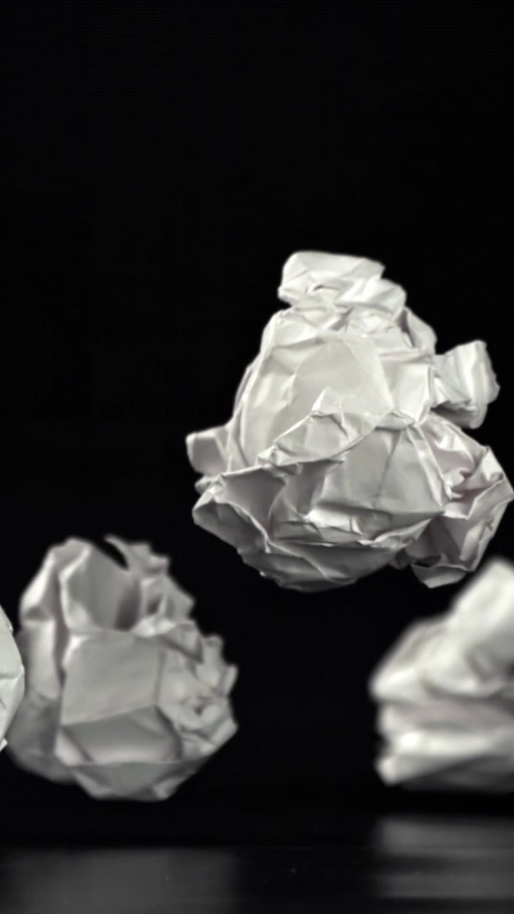 Palline di carta bianca accartocciata che cadono e rimbalzano al rallentatore