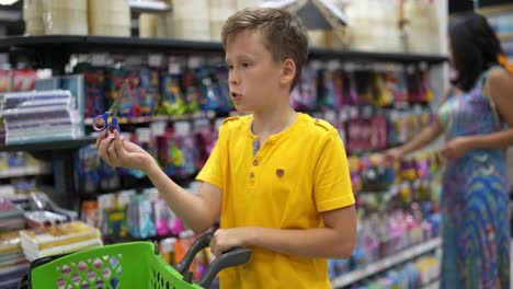 boy choosing stationery. young boy buying school accessories in supermarket