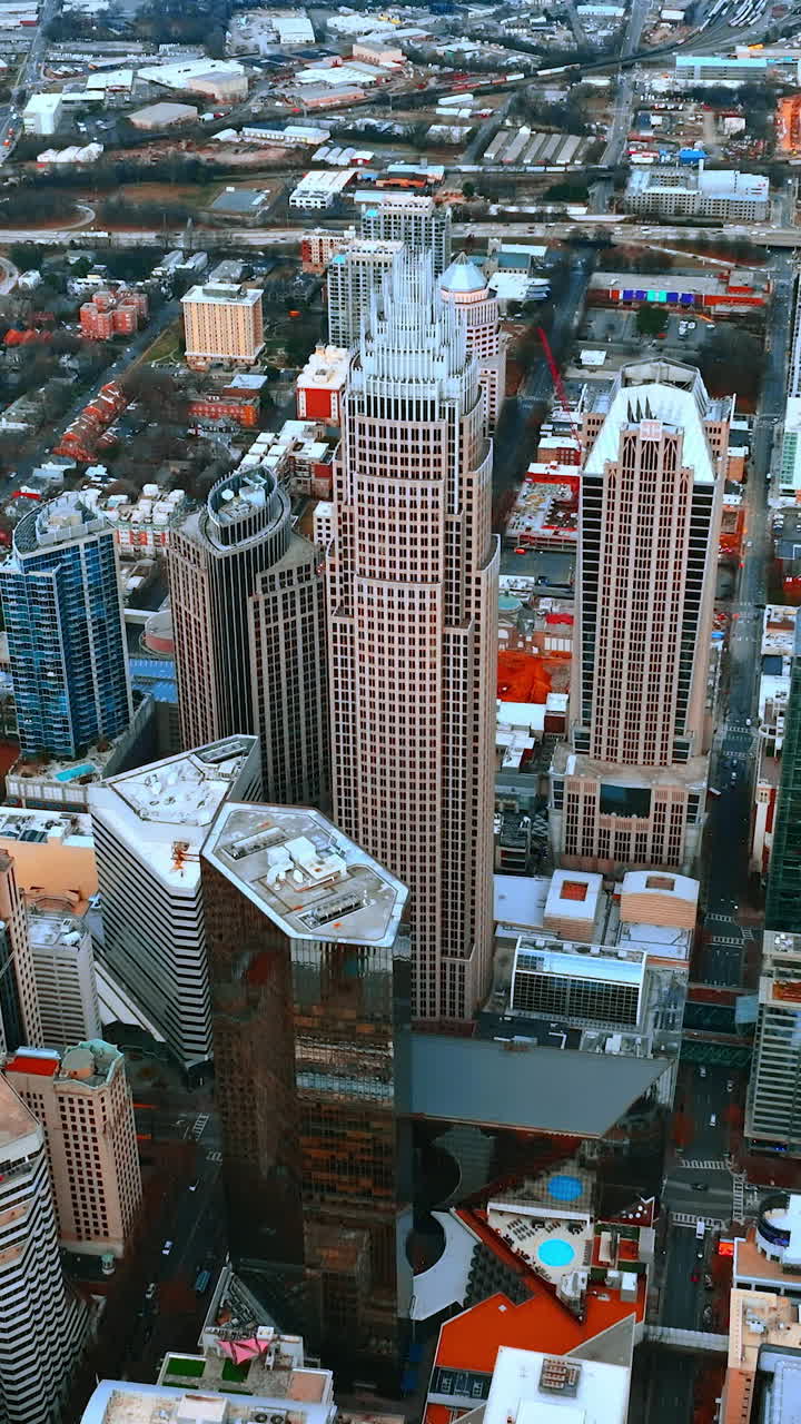 Panorama urbano moderno di Charlotte, Carolina del Nord, USA. Volo con drone sopra il centro della città, con imponenti grattacieli ed edifici bassi tutt'intorno. Video verticale