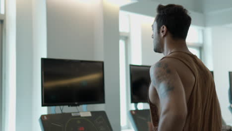 hombre activo en el 30 correteo o correr en cinta de correr en un gimnasio moderno en cámara lenta