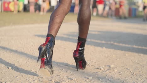 a close up of a person walking on gravel with high heels