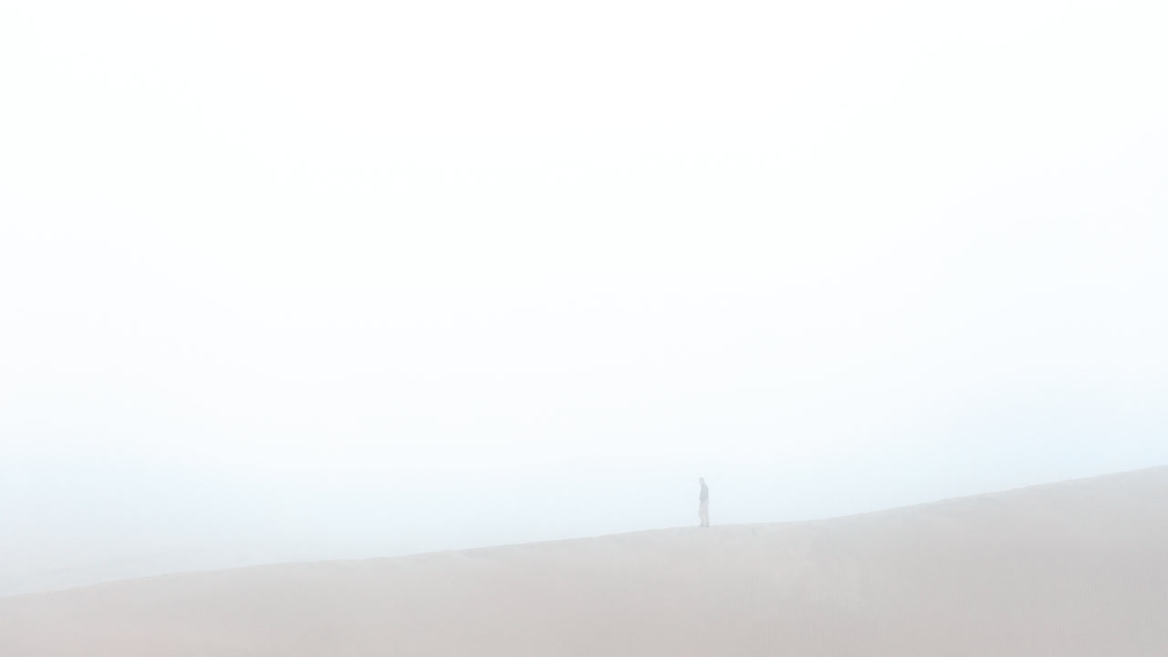 a man standing on a dune. Huacachina, Peru, desert, drone aerial