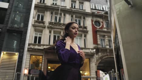 young female in purple dress is touching her body while the wind blow moving her hair and clothing very attractive slowmotion