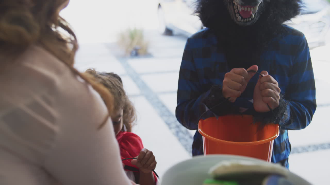 dos niños con vestidos de lujo fuera de la casa recogiendo galletas para el truco o el regalo de los abuelos