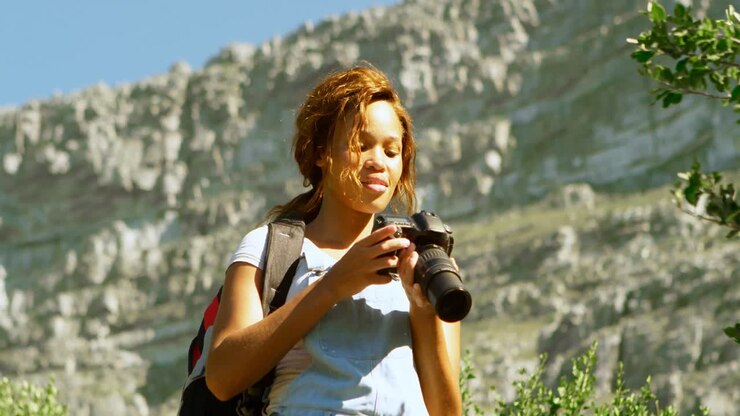 Female hiker clicking photos with digital camera 4k