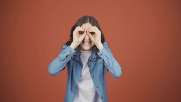 Young woman with binoculars looking away.
