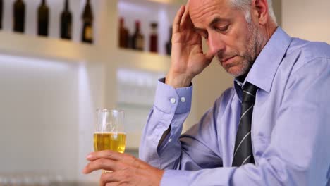 hombre de negocios preocupado bebiendo una cerveza después del trabajo