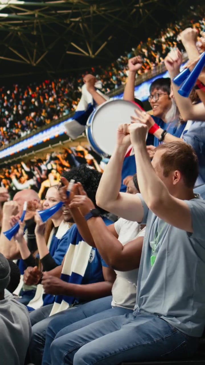 Video vertical: Aficionado de fútbol enérgico con megáfono liderando a seguidores que animan