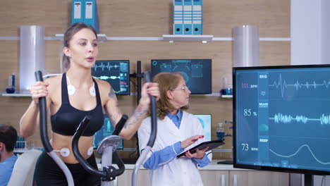 científica que monitorea la actividad cardíaca de una atleta femenina