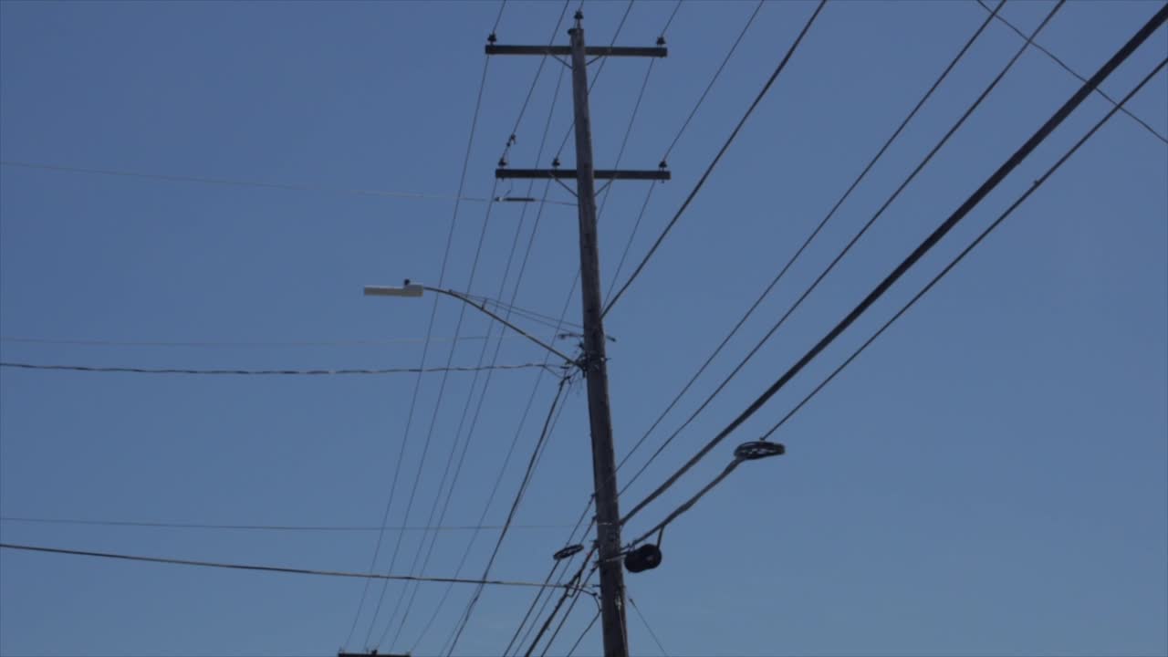 conducción por líneas eléctricas de la ciudad con cielos azules en segundo plano.