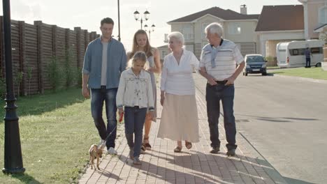 young family and elderly couple walking in countryside