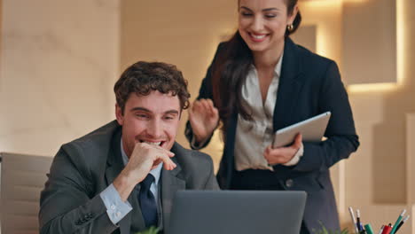 excited business team celebrating work success looking laptop at buro closeup