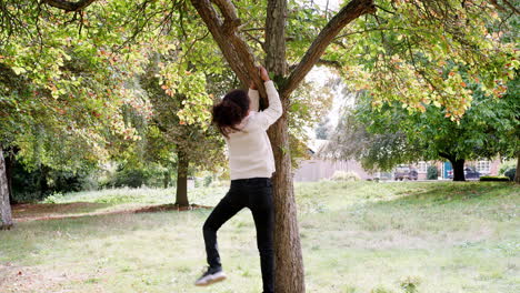 young mixed race girl jumping and climbing on an autumn tree, handheld