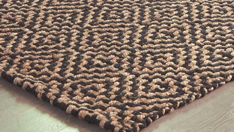 camera sweeps over patterned rug resting on polished wood boards