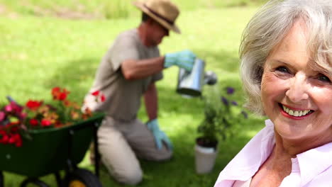 retired woman watching her husband gardening