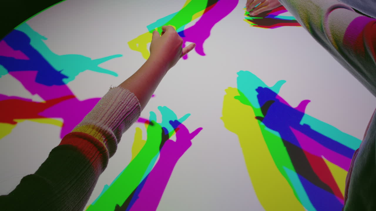 manos coloridas haciendo marionetas de sombra niños divirtiéndose jugando en luz multicolor niños disfrutando de un juego juguetón con siluetas de colores arco iris