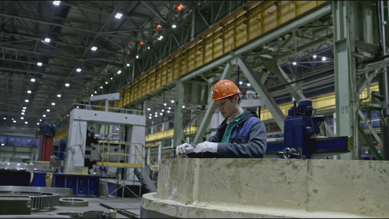 Factory worker inspecting machinery